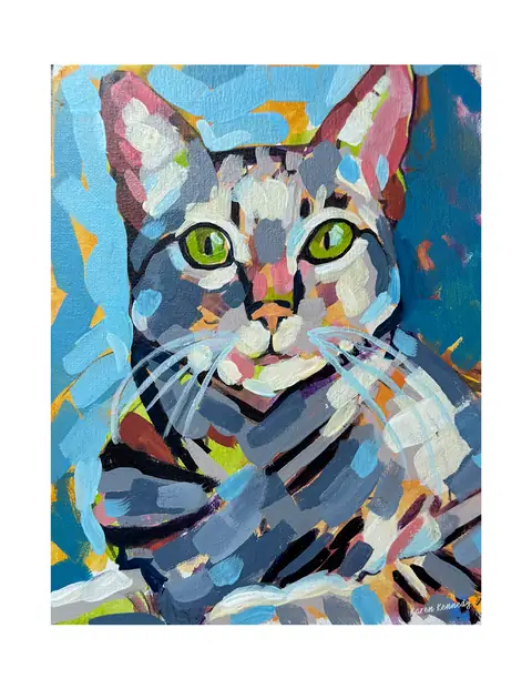 A tabby cat with green eyes against a colorful background.